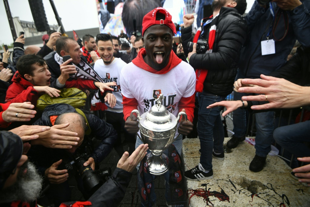 La joie de l'attaquant sénégalais de Rennes Mbaye Niang, avec le trophée de la Coupe de France, le 28 avril 2019 au Square Charles de Gaulle à Rennes, au lendemain de la victoire en finale face au Paris Saint-Germain (2-2, 6-5 t.a.b.) au Stade de France à Saint-Denis